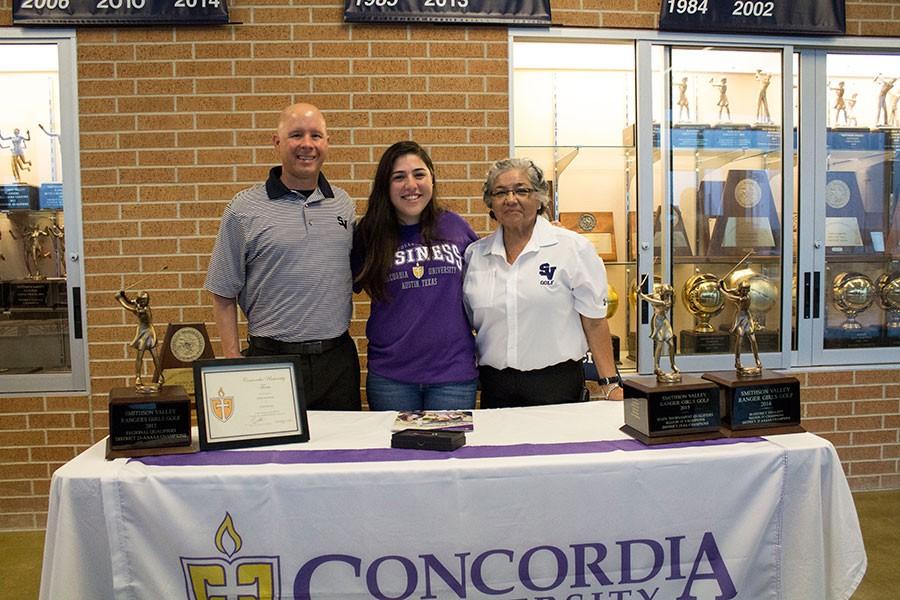 Flanked+by+her+golf+coaches+Jason+Pape+and+Delia+Alderete%2C+senior+Holly+Mendez+signs+her+letter+of+intent+to+play+golf+at+Concordia+University+March+8+in+the++main+gym+foyer.