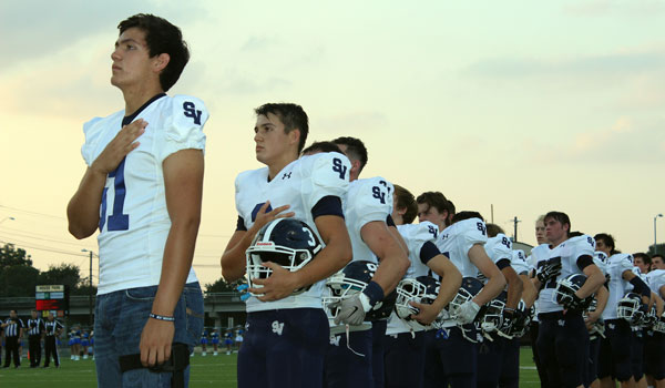 Football players stand for the national anthem for Fridays victory over Austin Anderson.