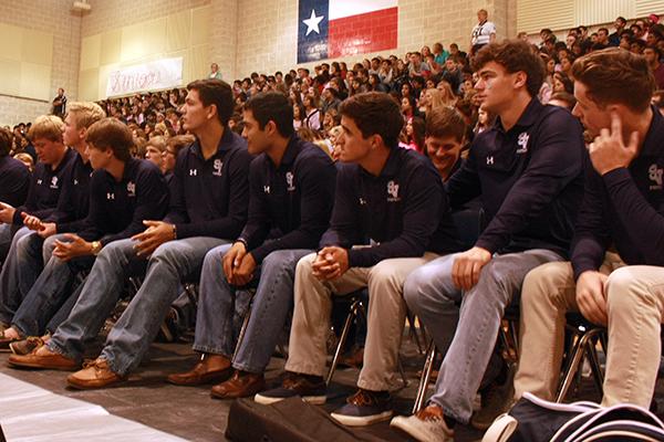 Varsity football players sit in the seats of honor during the pep rally Oct. 21