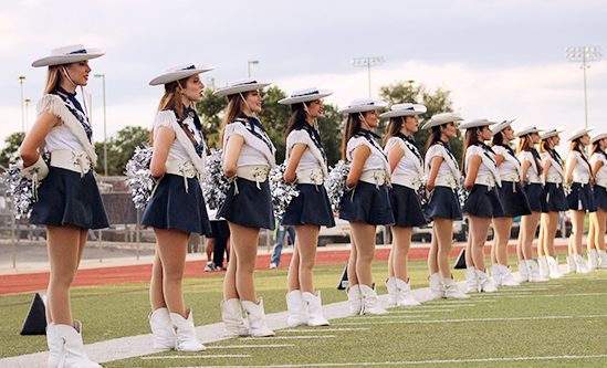 The silver spurs dance team lines the field at Ranger Stadium. They waited to welcome the football team onto the field and kickoff the game.  