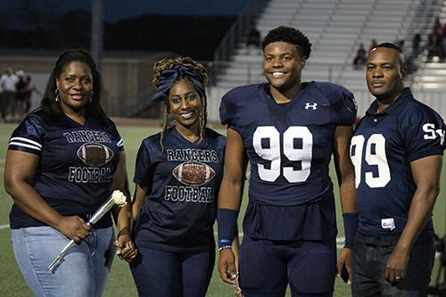 Brandon Arnold stands with his mom Shirley Arnold-Moore, sister Brittney Washington, and dad Carl Moore at Senior Night Oct. 28.