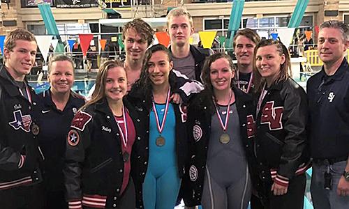 Coach Kari Osborne and principal Michael Wahl celebrate with swimmers advancing to state after medaling Saturday at the region meet.