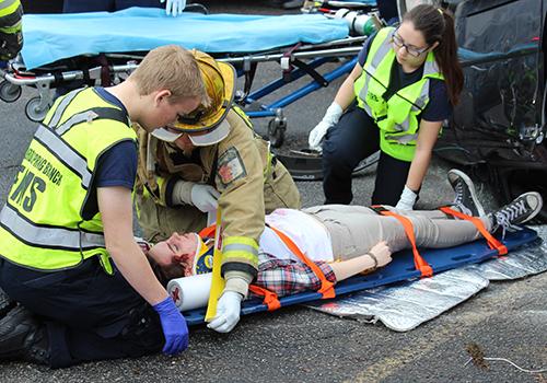 EMT students Jacob Seago and Katie Ecoff help a first responder tend to accident victim Lindsey Curtis during Shattered Dreams.