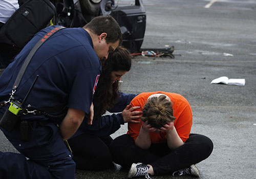 A first responder consoles Anna Elliott and Emily Harrison after the mock crash scene for Shattered Dreams on Thursday,
