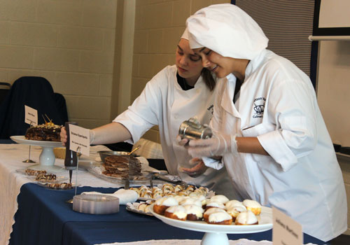 Andie OBrien and Briana Esperiqueta put the finishing touches on the dessert table. “I made a chocolate hazelnut crepe cake, OBrien said.  I saw it on Pintrest, so that’s why i made it. Esperiqueta made mini cannolis with chocolate chips. I made it because I love cannolis, she said.
