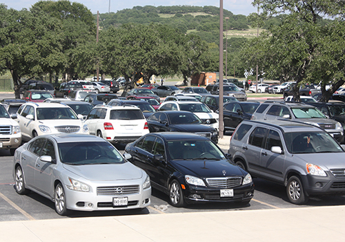 Cars parked in the front of the school.
