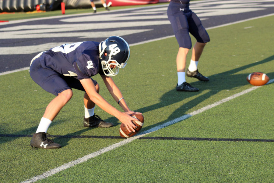 Junior John Beck snaps the ball during warm-ups before the teams home game against Round Rock. The team won 50-10 on Sept. 15 at Ranger Stadium