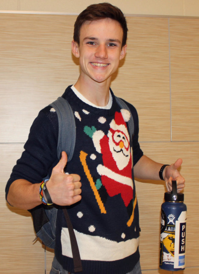 Junior Liam Weeks gives ugly Christmas sweater Thursday a thumbs up in A wing.