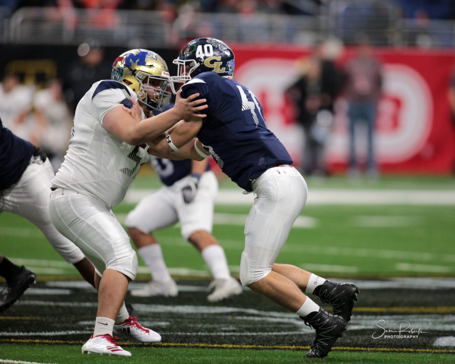 Senior defensive end CJ Kuehler takes on a block against the West left tackle in his pursuit to the quarterback.