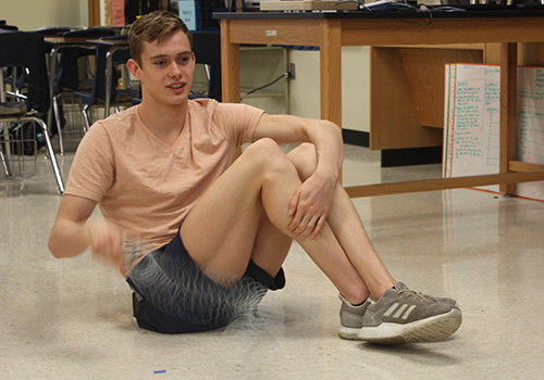 Junior Konnar Klinksiek oscillates the helical spring Feb. 28 in his physics class to see how waves interact.