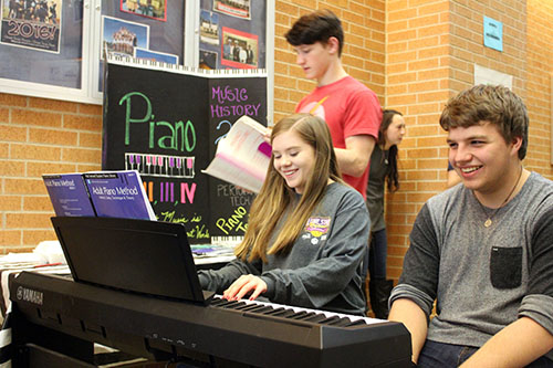 Juniors Ross Stoutamyer and Jager Overson watch as Baileigh Creighton shows off her piano skills for the incoming students.