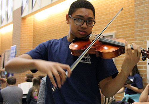 Levoun Ombava plays the violin and shows off the skills he has learned in his orchestra course.