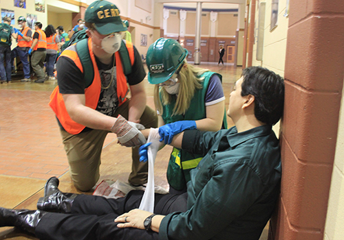 Senior Luke Snell and sophomore Ally Cravens help Jason Gonzalez recover form a dangerous injury during their Community Emergency Response Team training on Feb. 27.