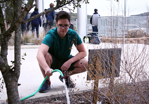 Junior Thomas Gallagher waters the Humans of SV garden during the garden meeting on Jan. 18. Anyone can water their plants this Sunday for Earth Day as well.