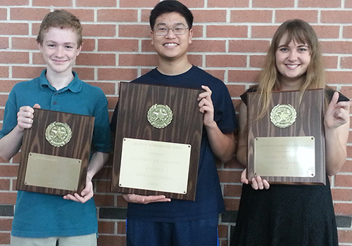 Junior Trent Pannkuk, sophomore Brandon Ling, and sophomore Maddie Aguilar hold the plaques won this weekend. 