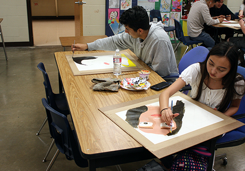 Junior Bryan Gil and freshman Samantha Lira work on their self portraits for Art 1 on April 17.