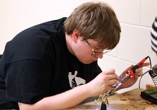 Senior Samuel Chroniak works on the soldering project for his engineering class on April 23. 