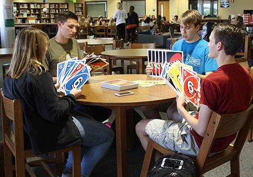 Seniors Jonathan Owen, Lucas Stewart, Logan Garner and Cassandra Frazier play a game a giant uno in the library durring their off period on May 11.