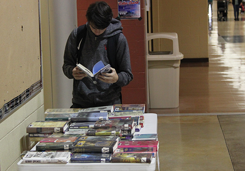 Sophomore  Branson Sappington looks through one of the free books outside of the library on May 1. 