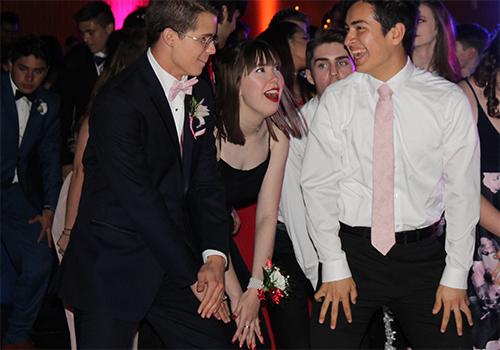 Seniors Garrett Snowden, prom queen Maggie Luhrman and Josh Martinez move their hands and legs to the music (from Prom 2018)