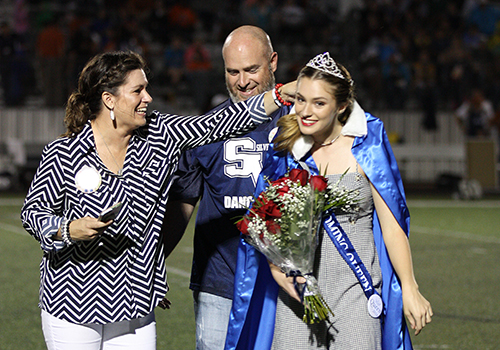 Homecoming queen Madi Forbes gets ready for her closeup with some help from her parent during halftime Friday.