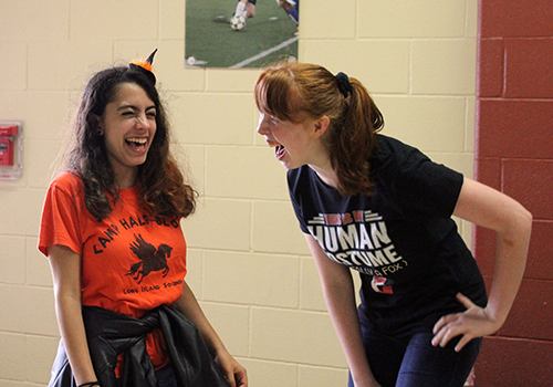 Dressed up for Halloween, sophomores Mia Quinones and Brenna Collins laugh at each other in the hallway near the rotunda.