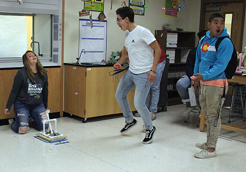 After hitting the target with a catapult they built, scientists Nicole Gomez, Joaquin Rodriguez and Gabe Altamirano in Christine Warzechas physics class celebrate.