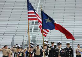 Before the 2017 Veterans Day ceremony at Ranger Stadium, the Naval Reserve Officer Training Corps presents the colors for the national anthem.