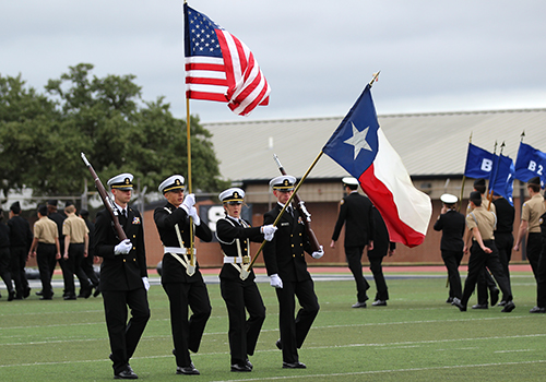 Junior Naval Reserve Officer Training Corps cadets present the flags at the beginning of the Veterans Day ceremony at Ranger Stadium.
