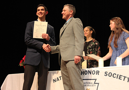 A newly inducted National Honor Society member, junior Carlo Garcia received his certificate and a congratulatory handshake from principal Michael Wahl on Nov. 30.