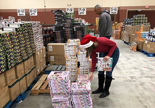 Sorting and wrapping gifts, Chief Daniel Hansen and FACS volunteers help Elf Louise conduct its annual gift giving project for children in need.