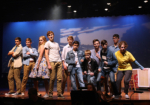 The Jets of West Side Story along with junior Rileigh McCullough end their act by posing center stage.