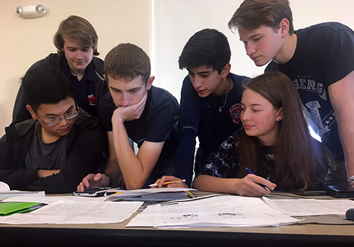 Senior Luke Estes assists math and science competitors as they wait for their next event in the Bandera High School cafeteria on Dec. 1. Senior Ross Stoutamyer and junior Audrey Pauletti are both on the right.