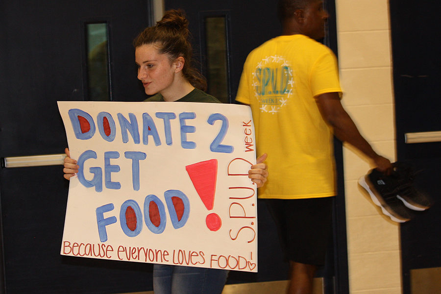 Julie Schultz holding a sign for donation, free food.
