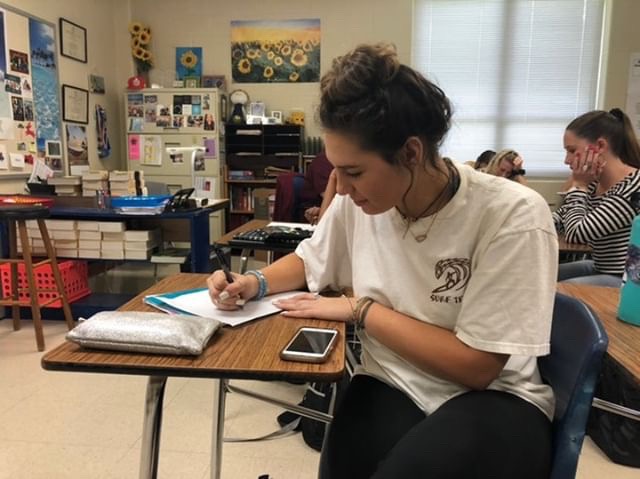 Senior Kayleigh Petray in her fifth period English class, writing in her preferred handwriting style.