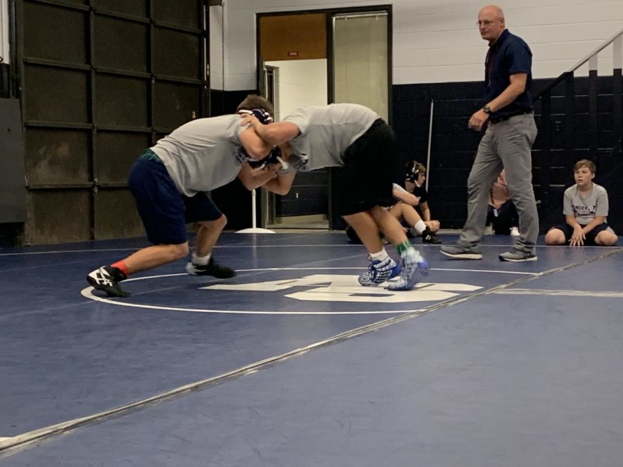 Under the watchful eye of coach Tim Clarkson, junior varsity wrestlers practice their techniques during first period on Friday.