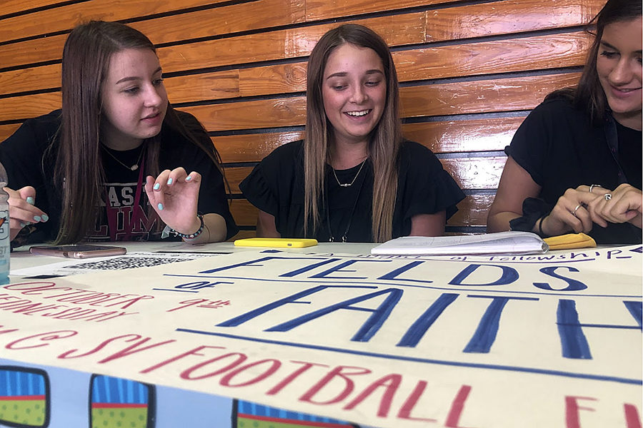 During C lunch today in the senior dining hall, SV United members Quinn Mckinley( 12), Alyssa Smith(11) and Jenna Kirk (11) set up the Fields of Faith desk in the senior dining hall during C lunch in hopes of collecting signatures for the event Oct. 9 at Ranger Stadium. 