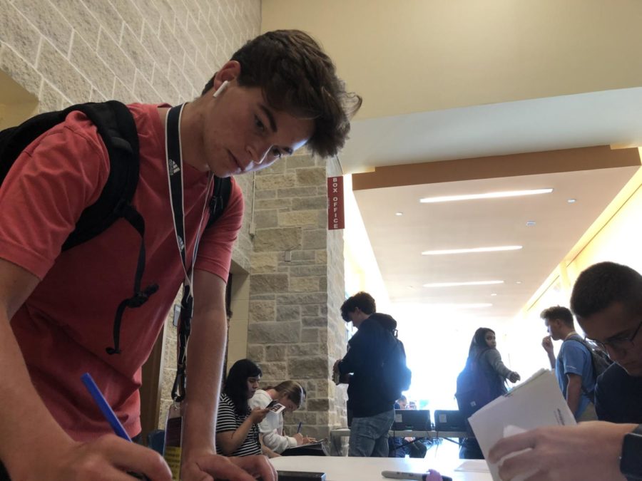 In front of the auditorium,  junior Brennan Tiller signs up to give blood during fourth period. South Texas Blood and Tissue Center collected donations today at the high school.