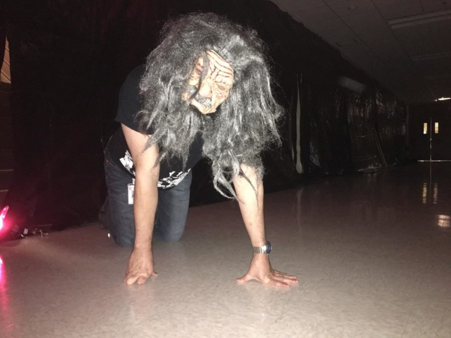As he creeps through the haunted house, student council sponsor Christopher Helkey scares those who dare enter.