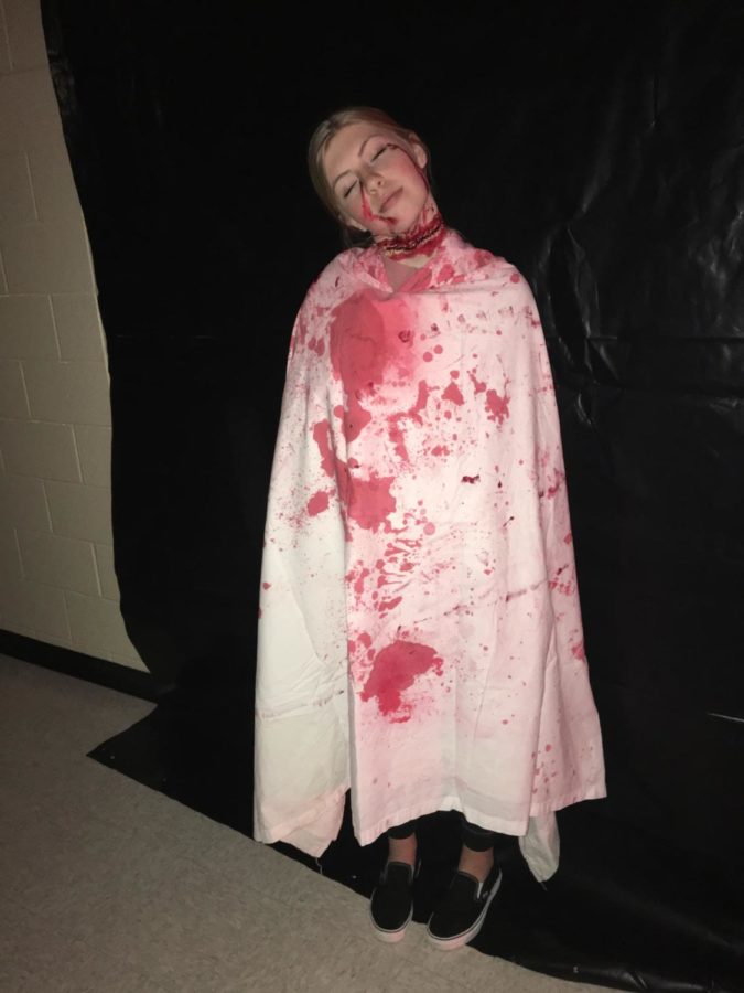 With bloody makeup and clothes, junior Madison Wilhelm prepares to scare in the slaughterhouse section of the haunted house.