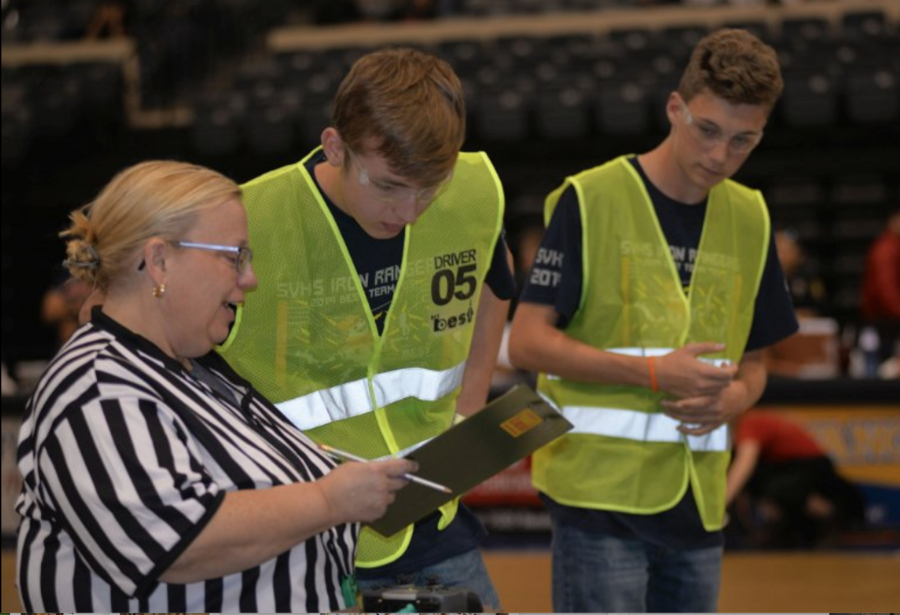 Before starting the robot game, SABEST robotics judge debriefs Brendan Wyatt and Nick Finley on the competition rules and point values. Wyatt and  Finley both drove the robot and spotted for each other during the contest.
