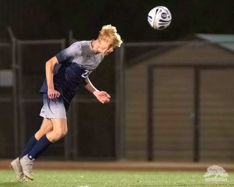 Senior Tyler Vanfossen heads the ball out of the defensive third. Vanfossen is one of the captains for the 2019-20 season.