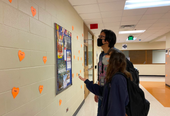 Grace Bush and Alex Dewees search for their valentine hearts in the halls. Student council put up a heart for every student and faculty member though the hallways.