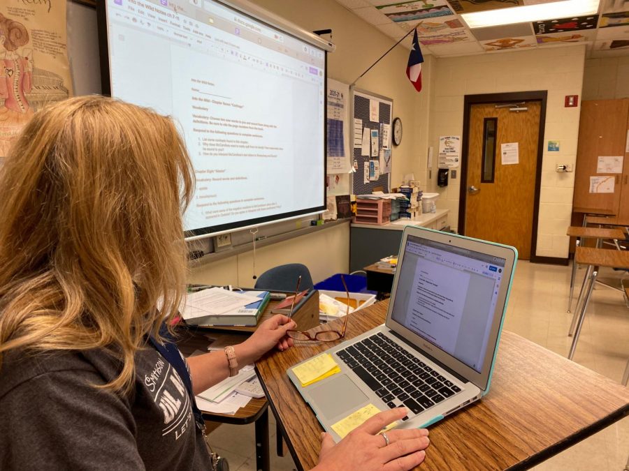 AP English III teacher Verna Mann presents the class assignment via projector for face-to-face students and shares her laptop screen on Google Meets for remote students.