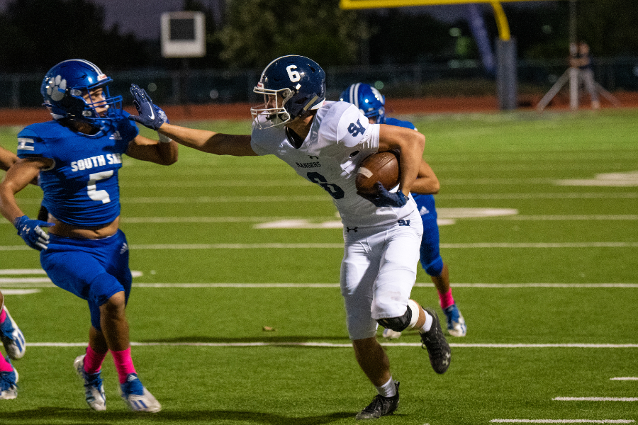 Stiff-arming a defender, Zack McDonald fights for yardage against South San on Oct. 15. McDonald caught a 37-yard pass late in the fourth quarter on Friday to set the Rangers up for a go-ahead touchdown.