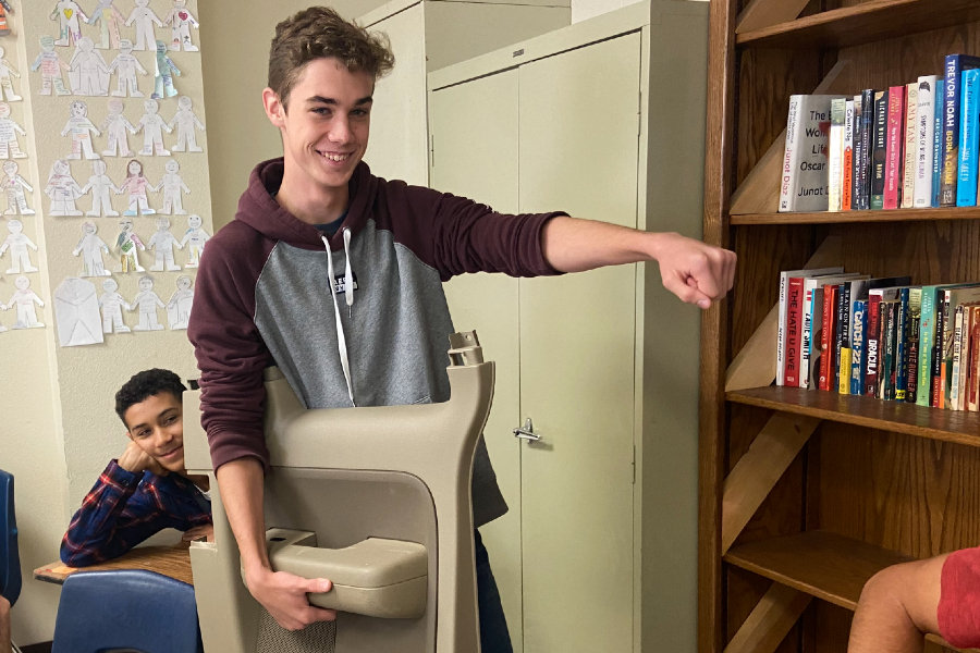While brandishing a broken car door, senior Jacob Norman totes his school supplies in an unconventional way for Anything But a Backpack Day. He repurposed the door after it fell off his fathers car. 