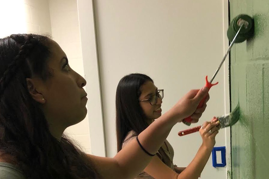 Jessica Adauto and Sylvana Gomez paint the teachers lounges walls green for a farm-style look.