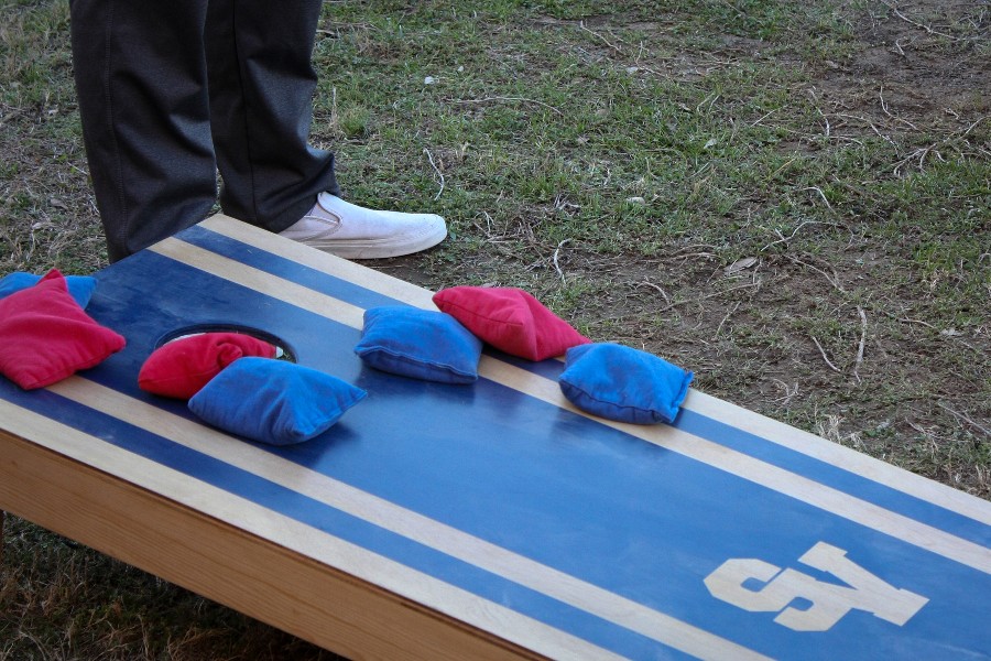Blue and red bean bags pile onto the board in a close game.