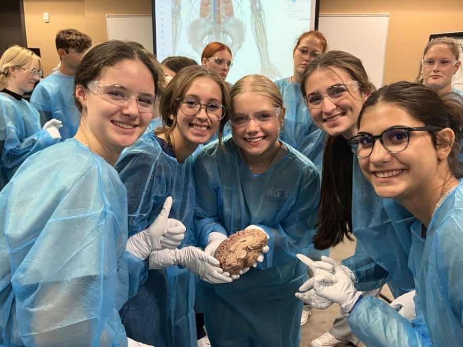  Ava Brown, Kailey Gonzales, Tanner Franks, Cara McCray, and Elisa Bertini hold a dissected human brain while on the field trip to a local cadaver lab.