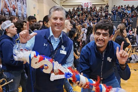 Hours after announcing his retirement to the faculty and staff, principal Michael Wahl celebrates with class president Aboudi Awad after the seniors win the spirit stick at the pep rally Dec. 2.